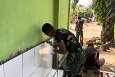 Anggota Satgas TMMD 128 Masukkan Adonan Semen kedalam Keramik Wudhu Mushola Ar-Rasyid 