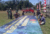 Sambut Penutupan TMMD Reg-129! Satgas TNI & Warga Desa Cukil Gotong Royong Pasang Banner